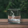 Load image into Gallery viewer, A clear glass with a white map of Mooselook Megantic Lake printed on it, placed on a wooden surface.
